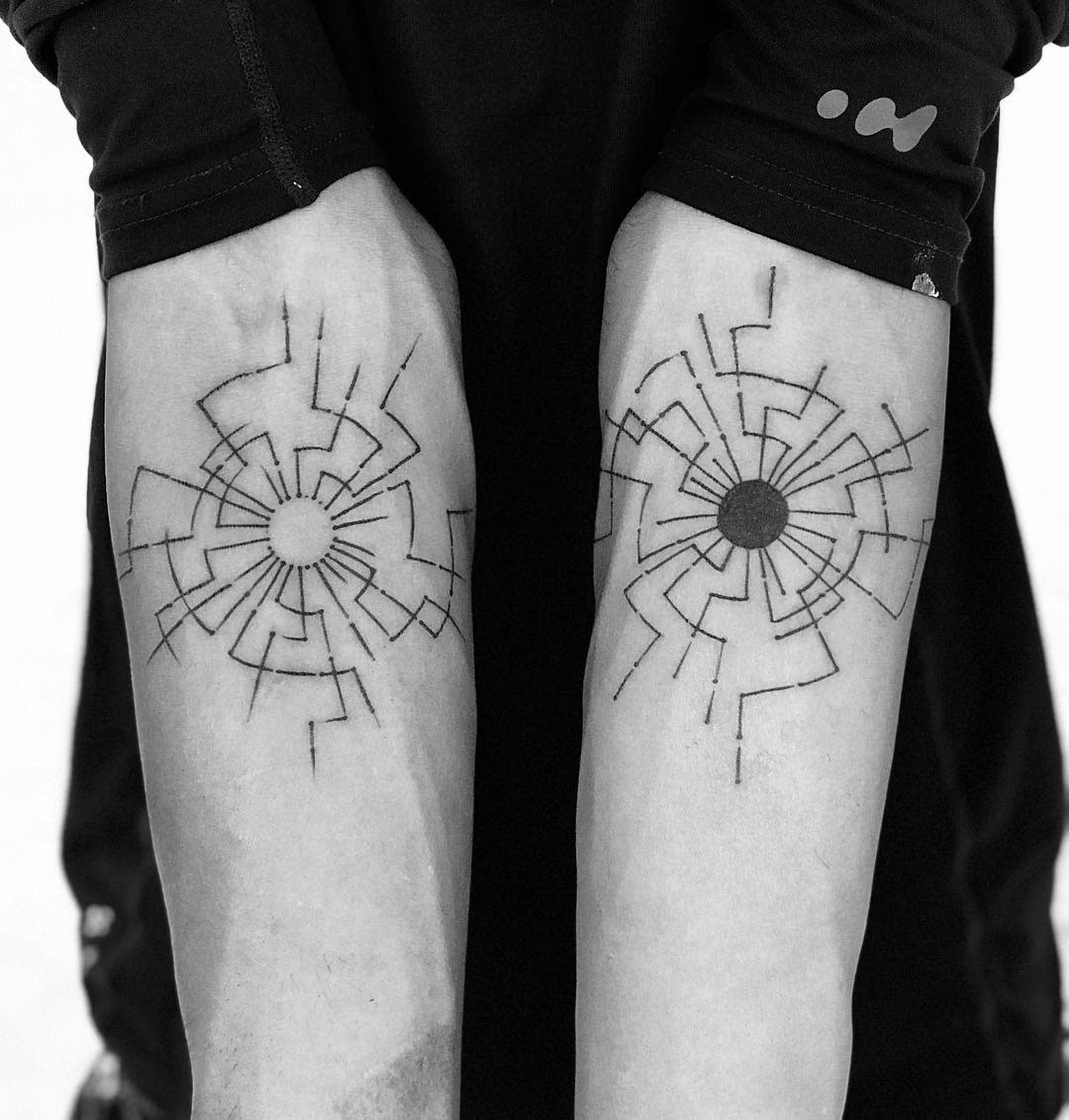 Minimalist cyberpunk tattoos on forearms featuring symmetrical circuit-like designs radiating from a central point